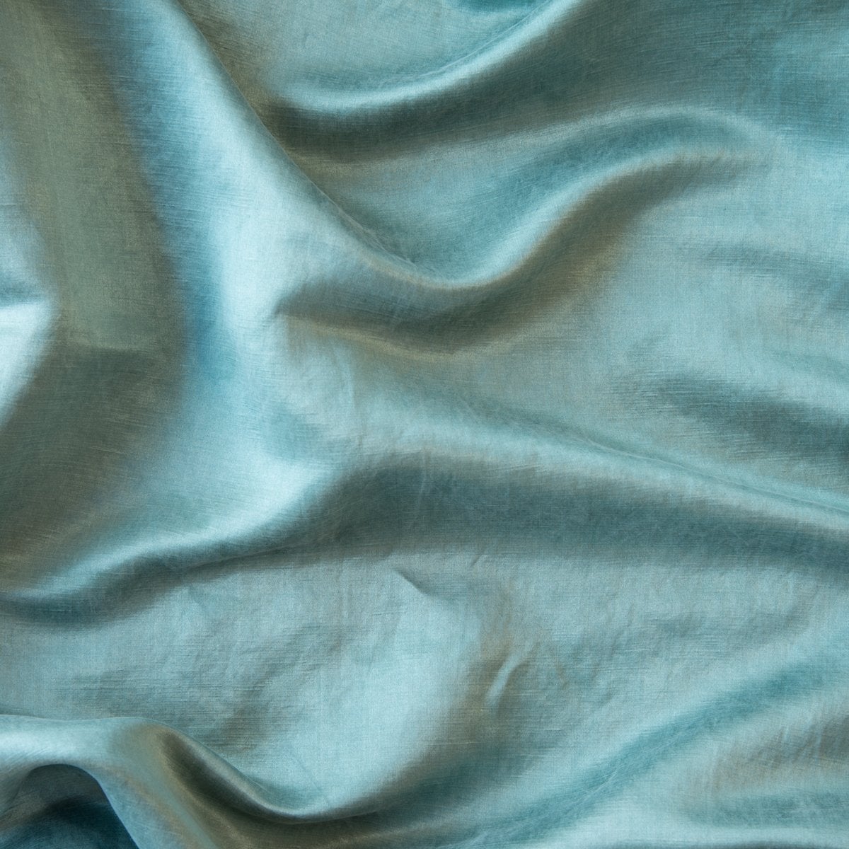 Cenote: Close-up of silk charmeuse in cenote, a vibrant, ocean-inspired blue-green.