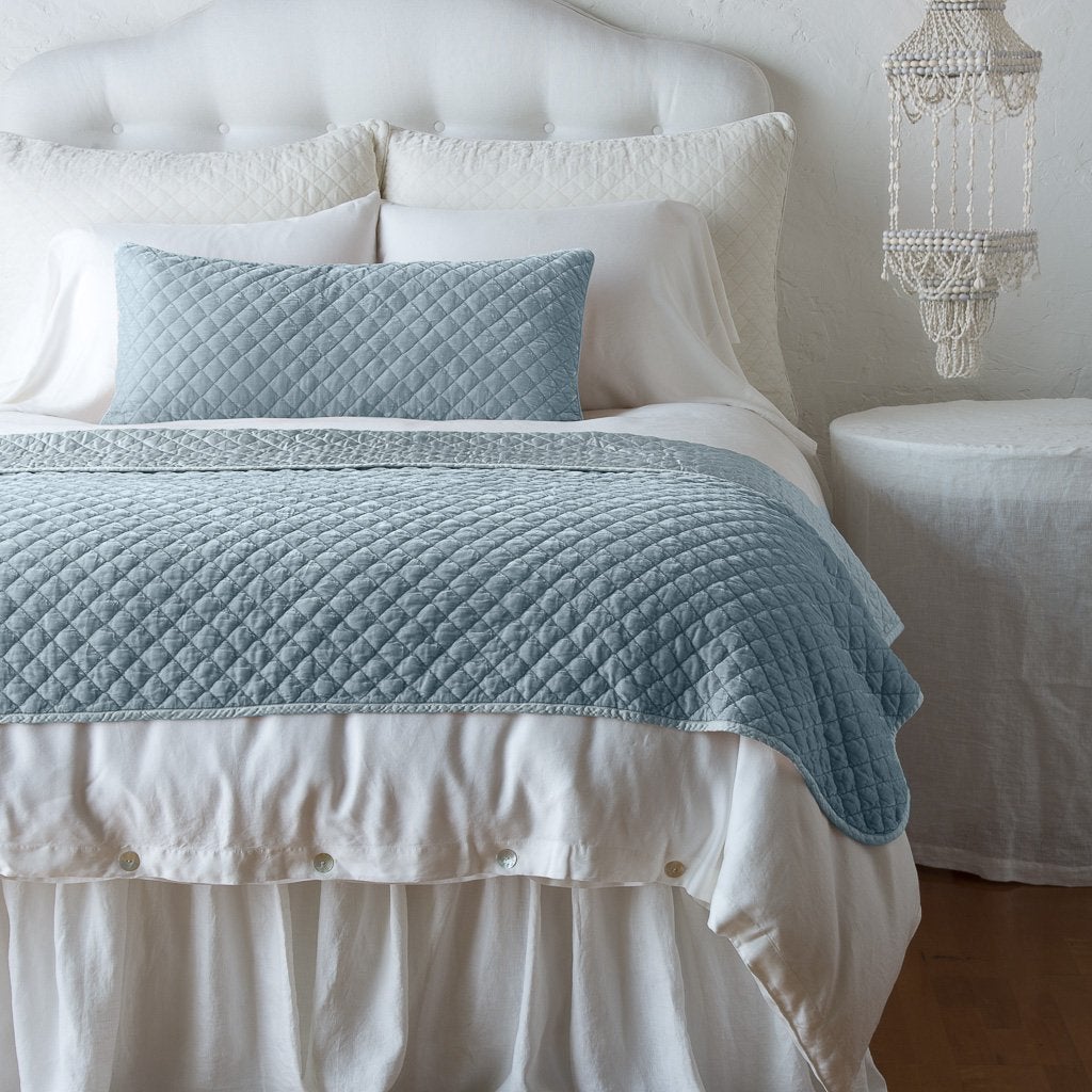 Cloud: 16x36 pillow and matching throw blanket on a white, neatly made bed - end of bed view.