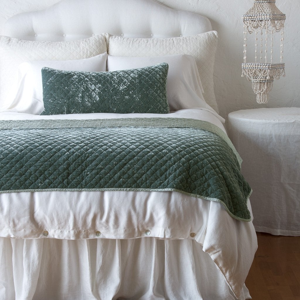 Eucalyptus: 16x36 pillow and matching throw blanket on a white, neatly made bed - end of bed view.