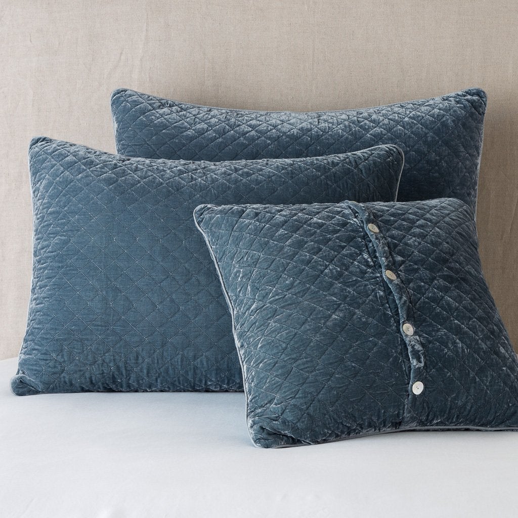 Mineral: shams leaning upright against a neutral headboard. One sham is backwards to showcase the shimmering shell button closure.