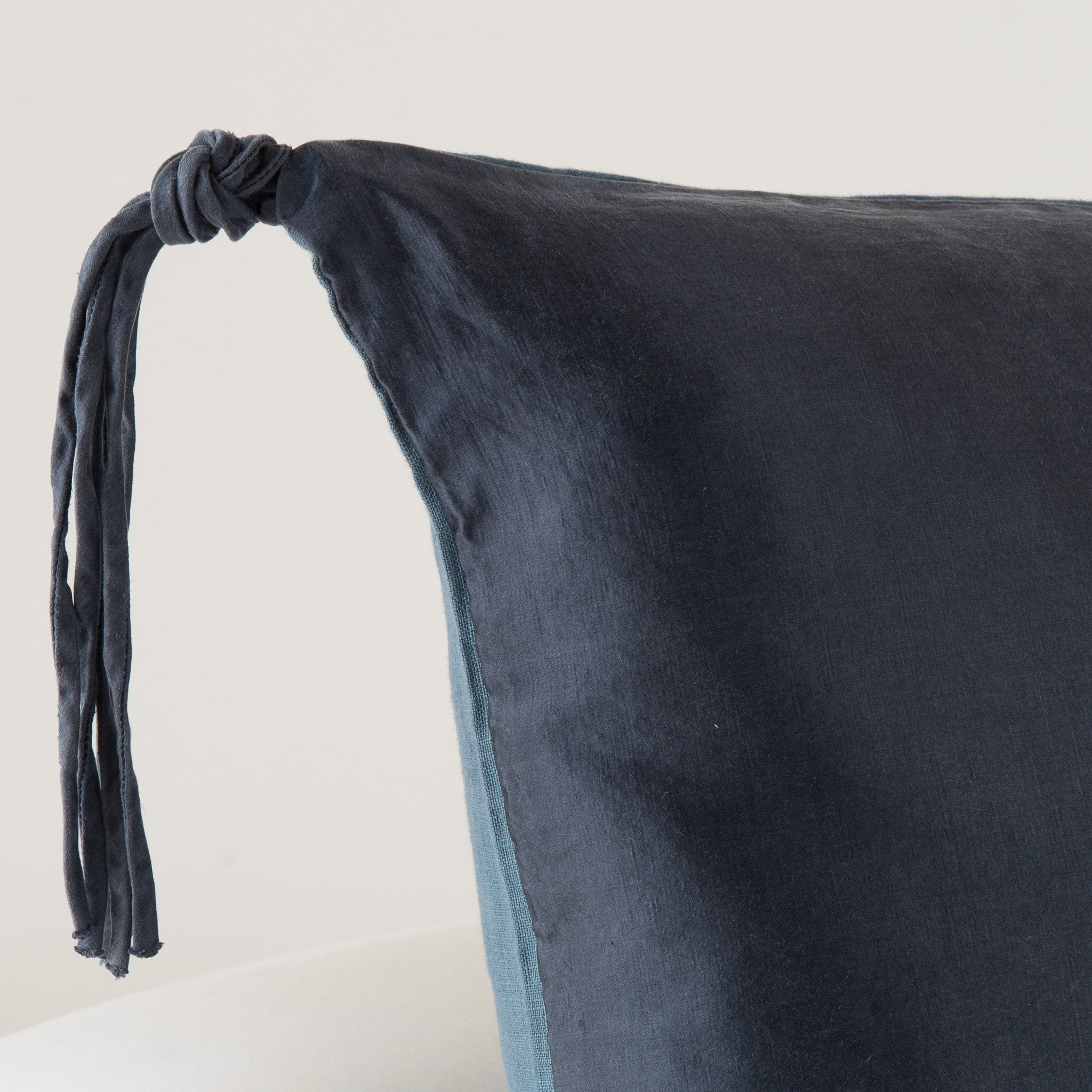 Midnight: Corner detail close-up, highlighting hand-tied charmeuse tassel.
