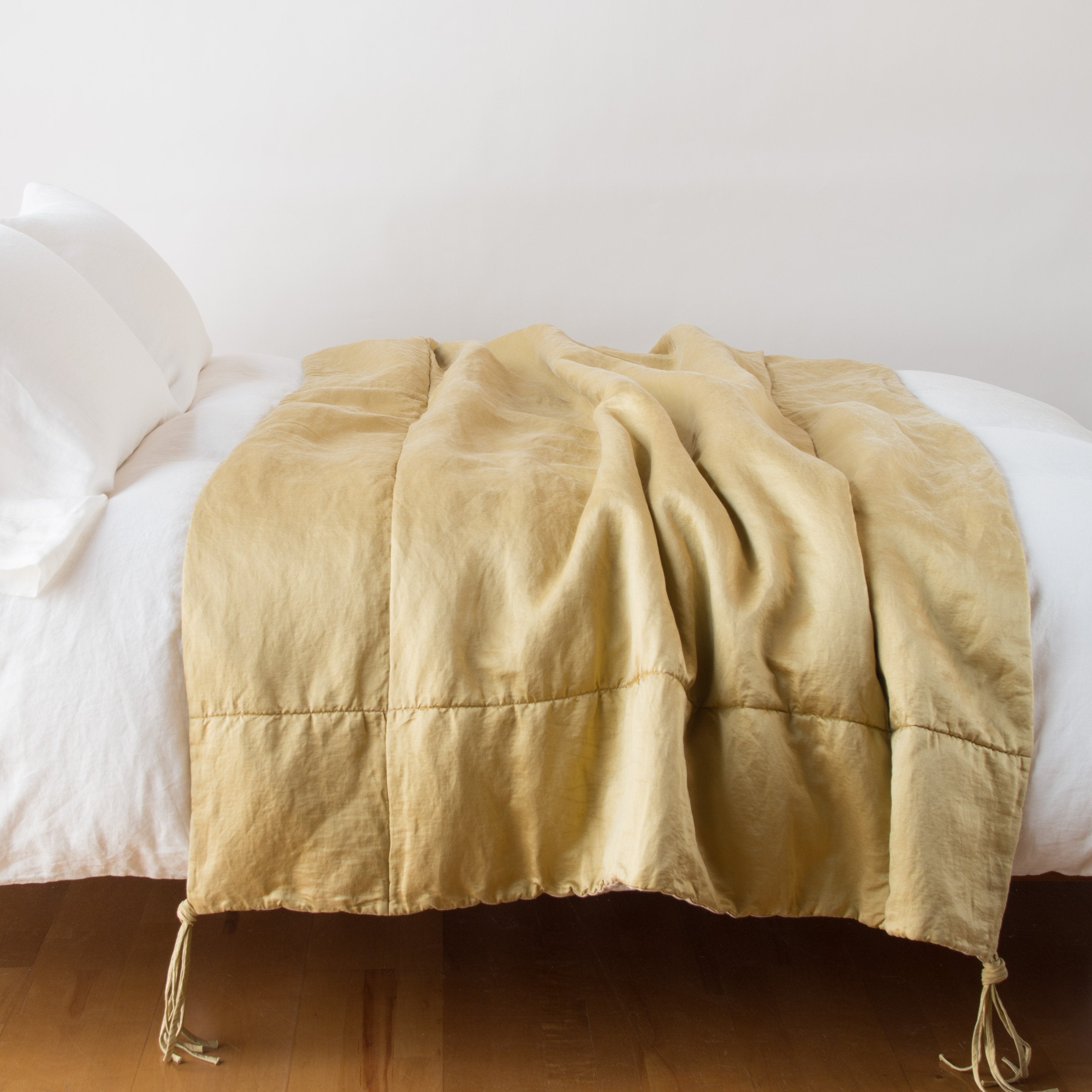 Honeycomb: Taline throw blanket draped over a white bed - honeycomb, side view.