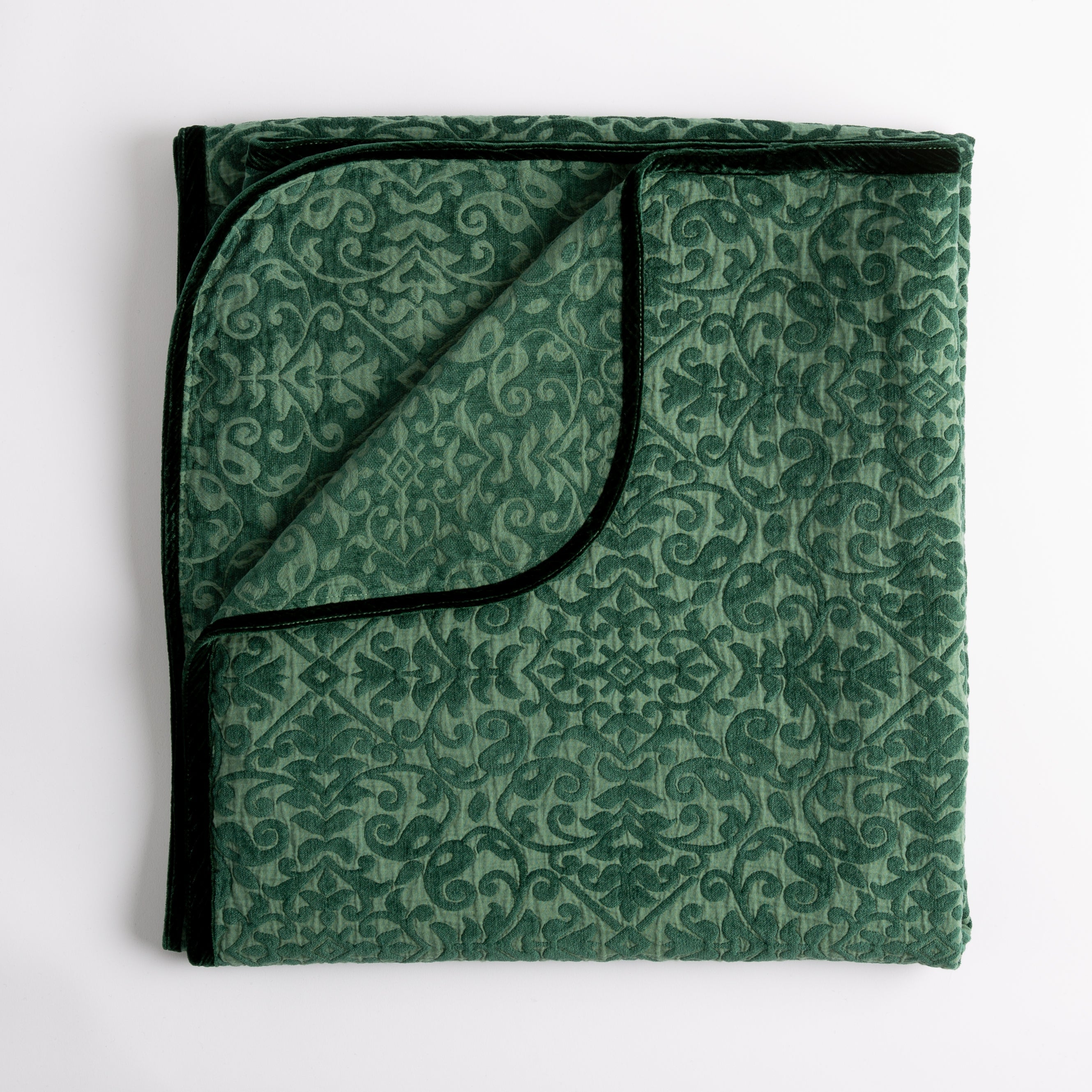 Jade: Folded cotton chenille jacquard blanket with corner folded back — overhead on a plain white background. 