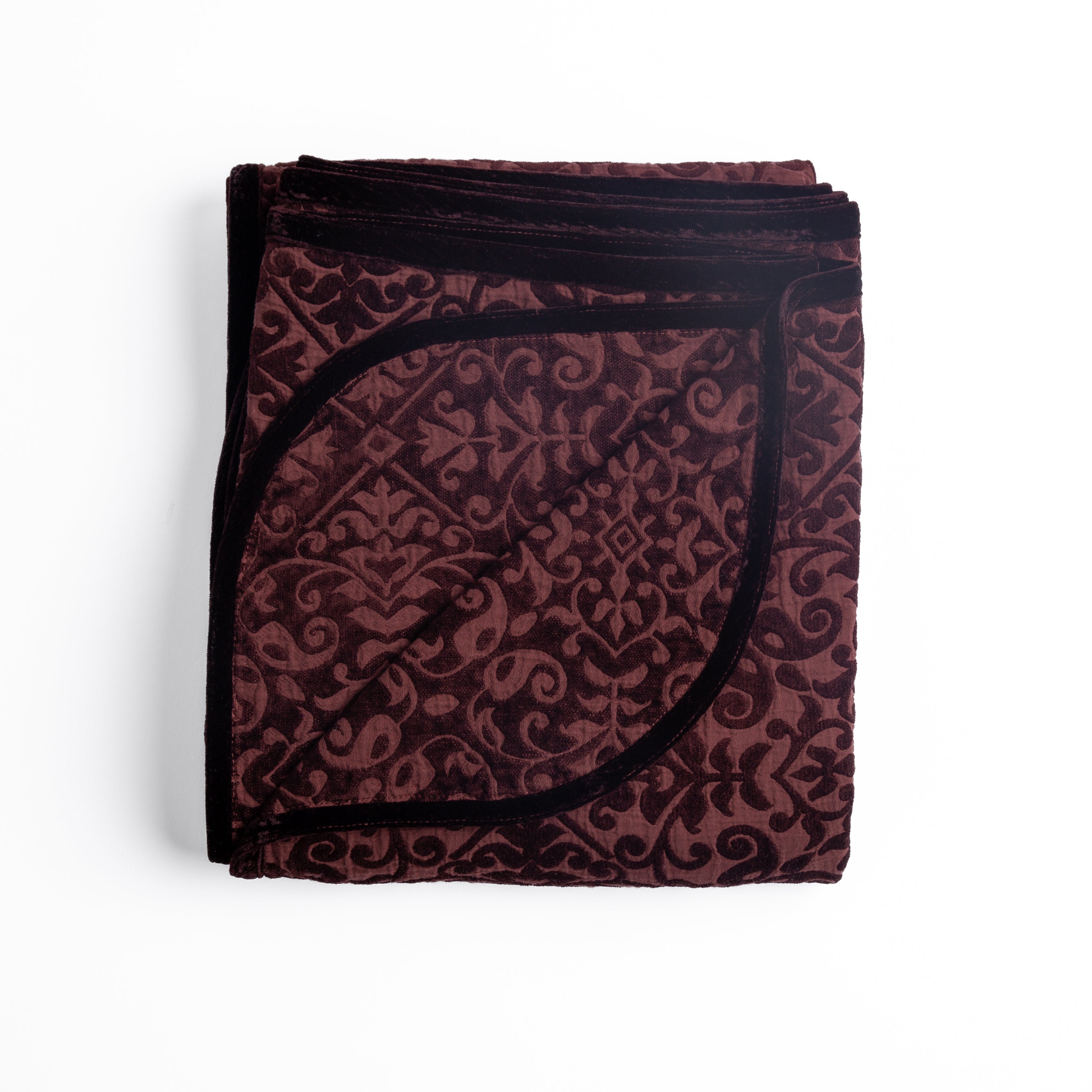 Mahogany: Folded cotton chenille jacquard blanket with corner folded back — overhead on a plain white background. 
