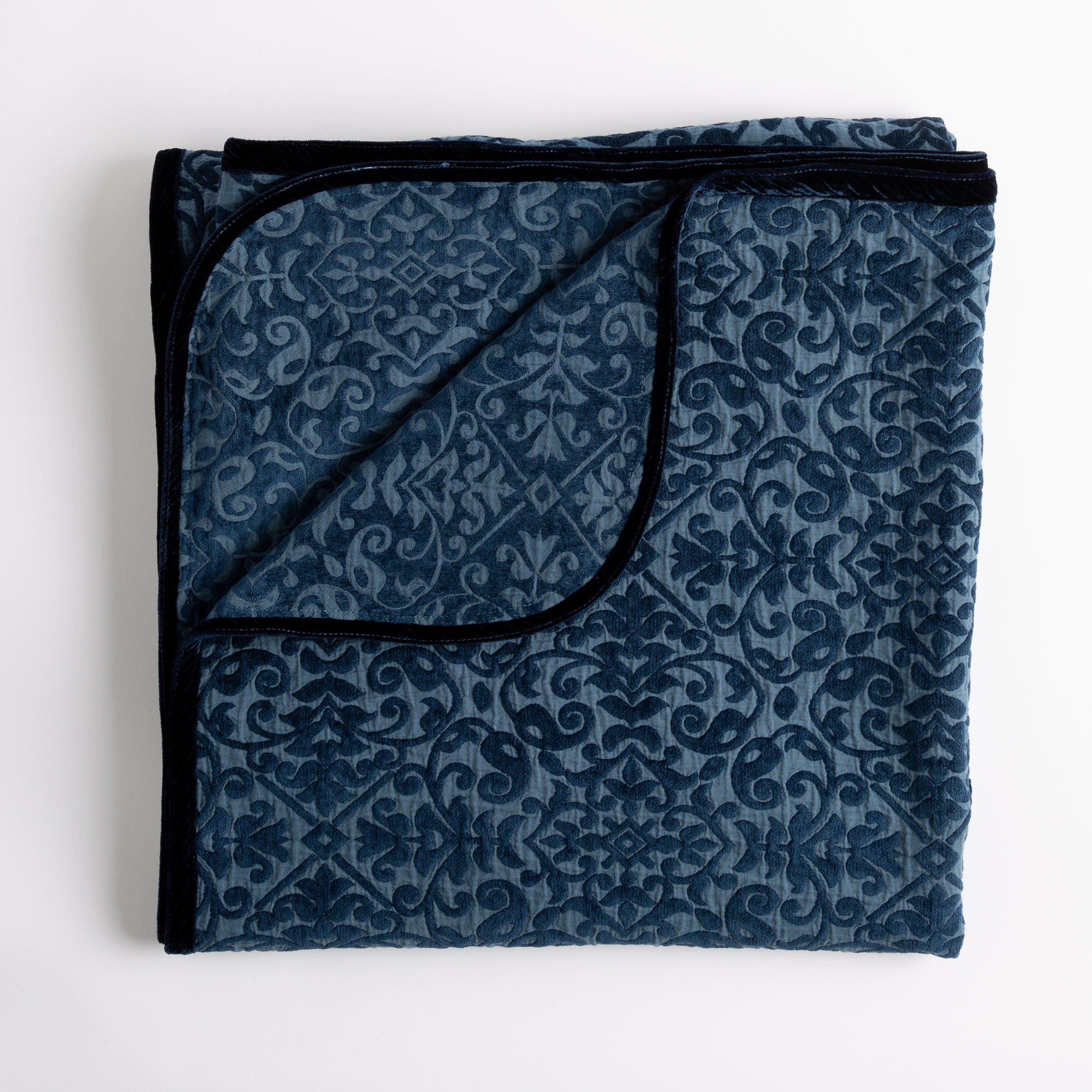 Midnight: Folded cotton chenille jacquard blanket with corner folded back — overhead on a plain white background. 