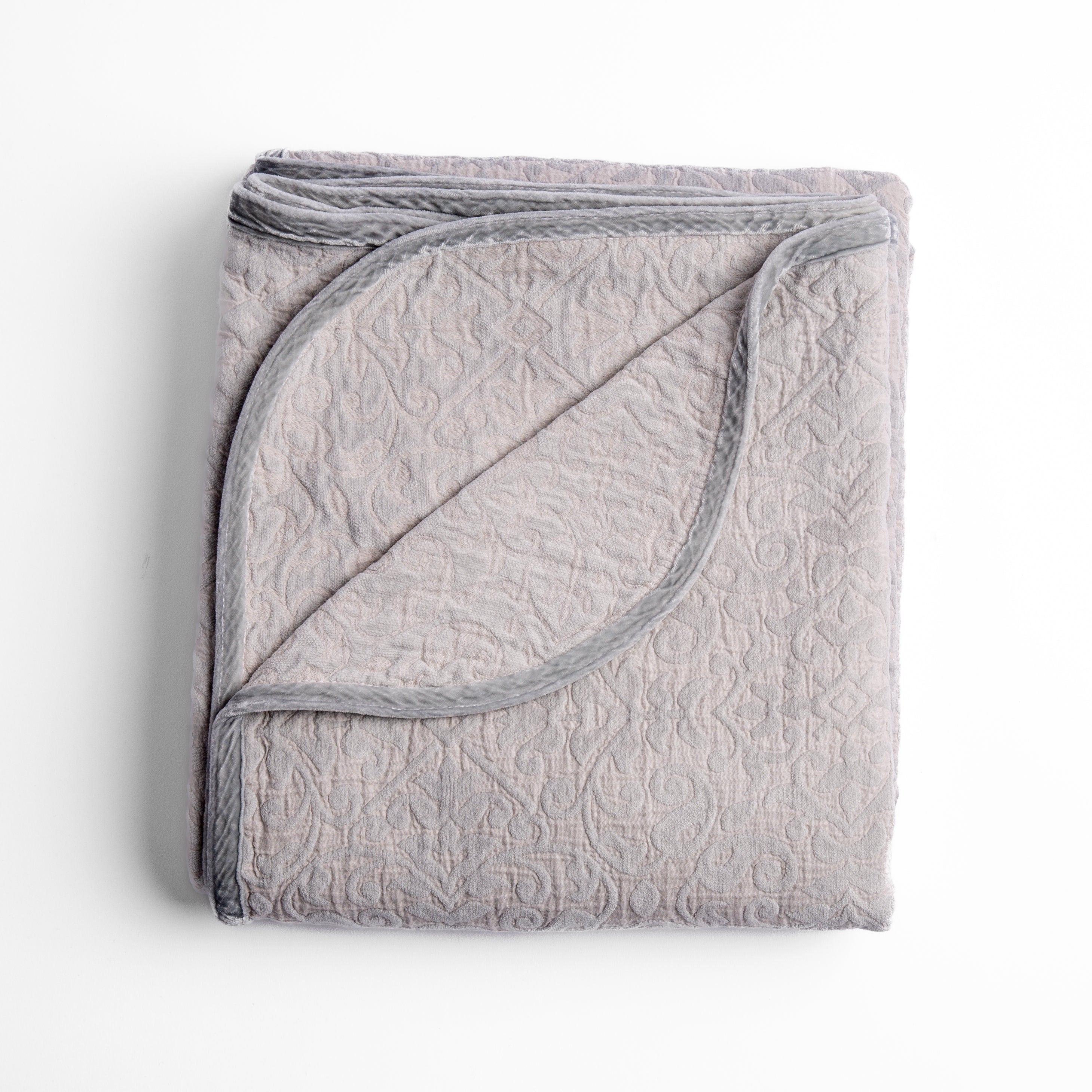 Sterling: Folded cotton chenille jacquard blanket with corner folded back — overhead on a plain white background. 