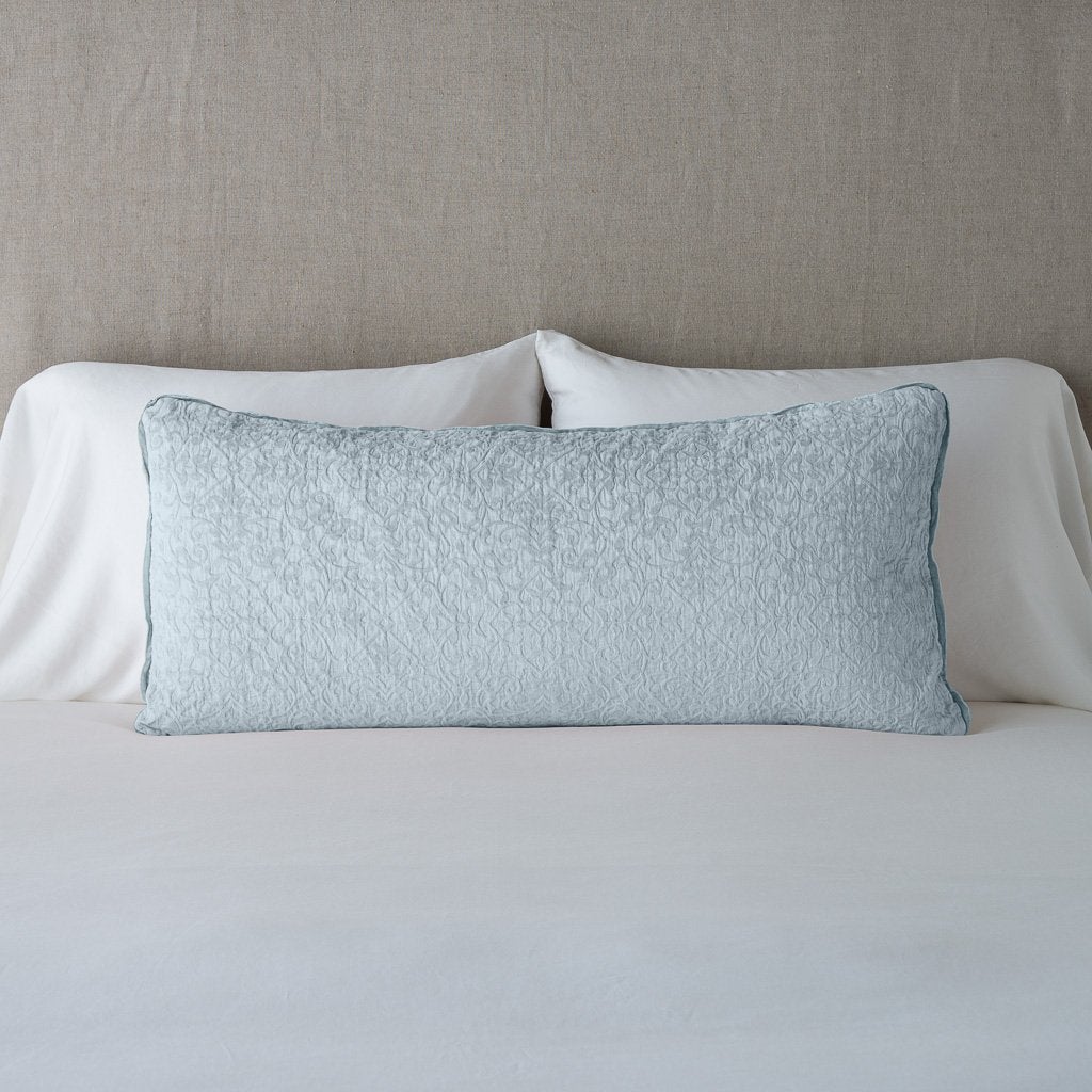 Cloud: 16x36 pillow leaning upright against white sleeping pillows on a neutral headboard.